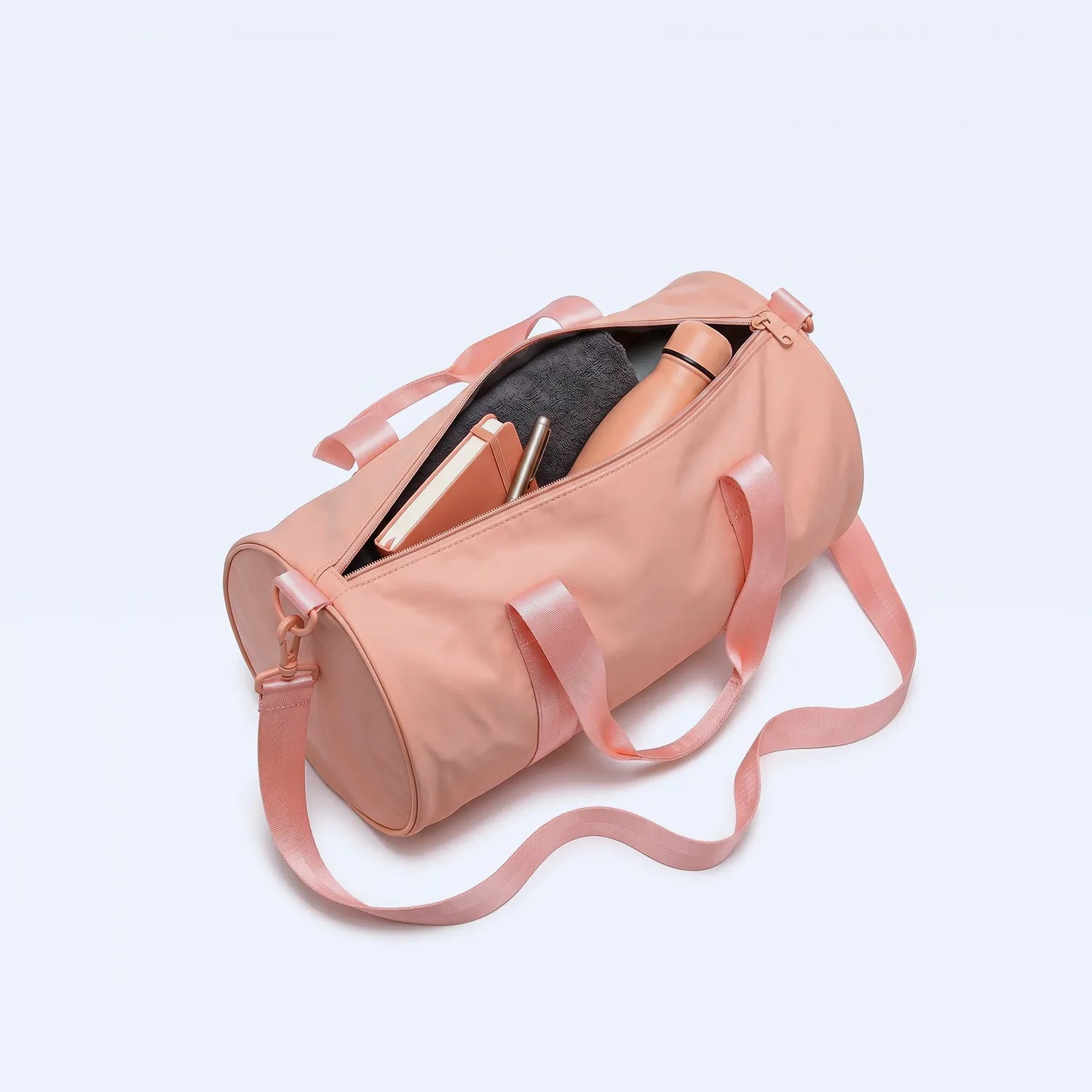 Pink duffel bag with ribbons on a light gray background