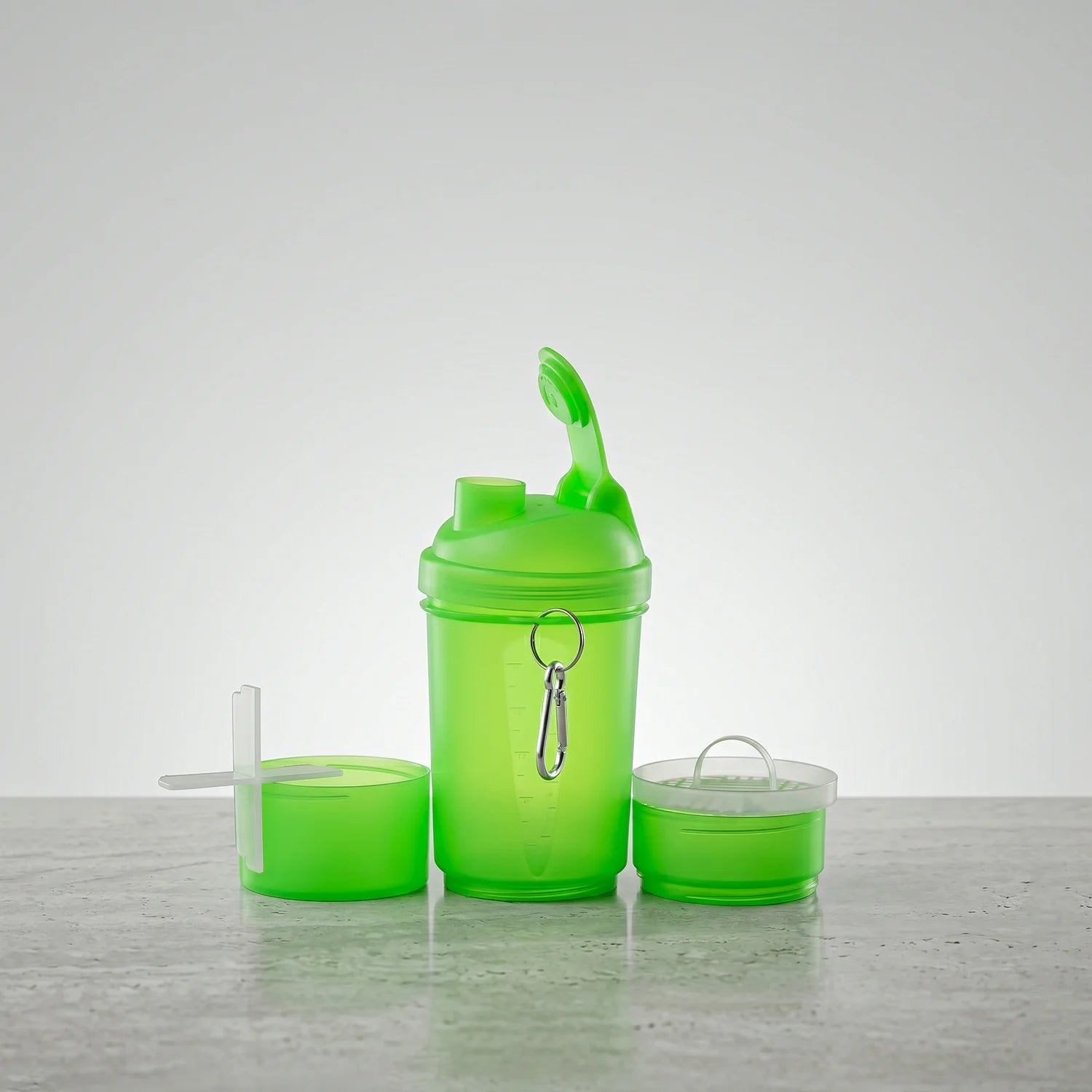 Green shaker bottle with accessories on a light gray surface