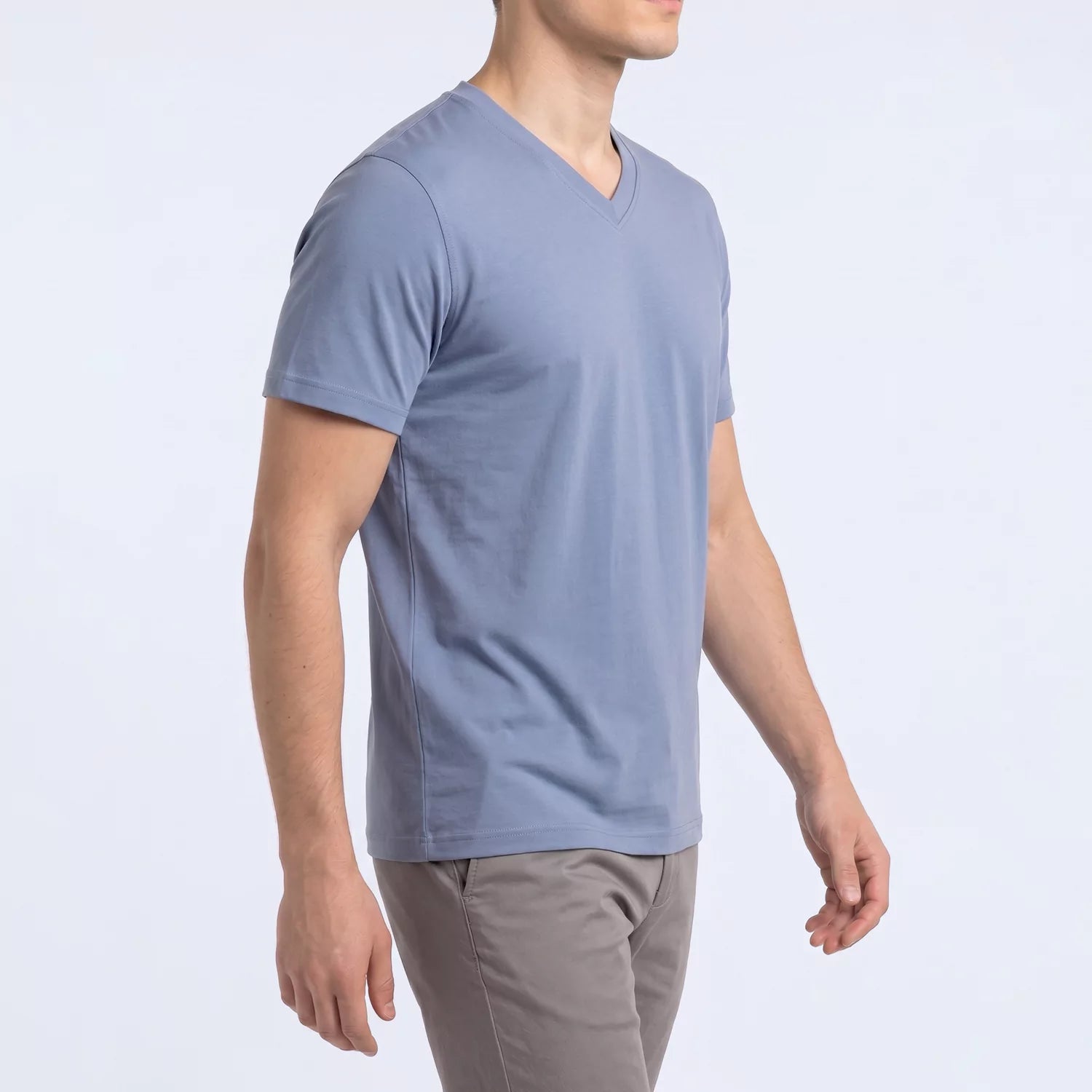 Side angle of the dusty blue Ember V-neck tee showing slim fit through the torso