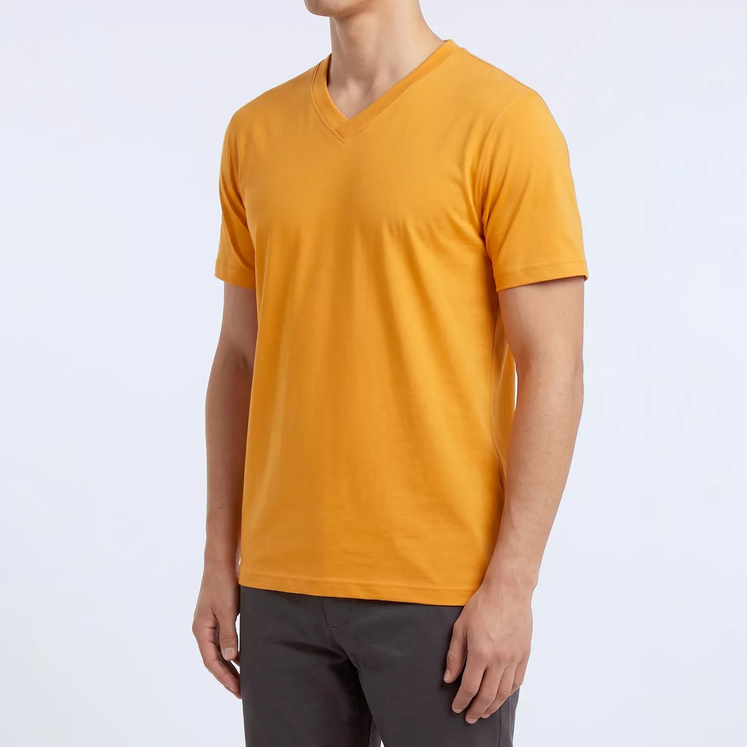 Side angle of the marigold orange Ember V-neck tee showing slim fit through the torso