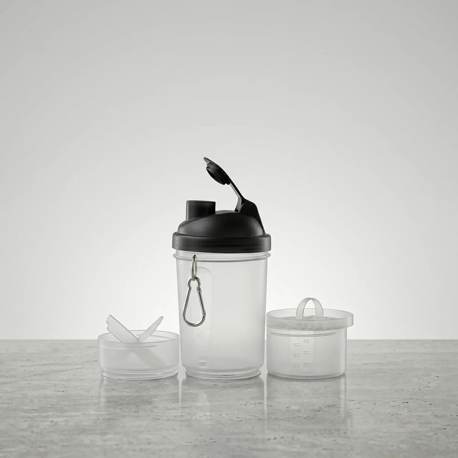 Clear shaker bottle with black cap on a light gray surface