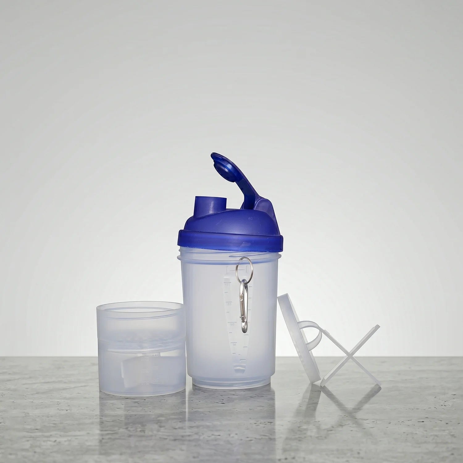 Shaker bottle with a blue lid on a gray surface